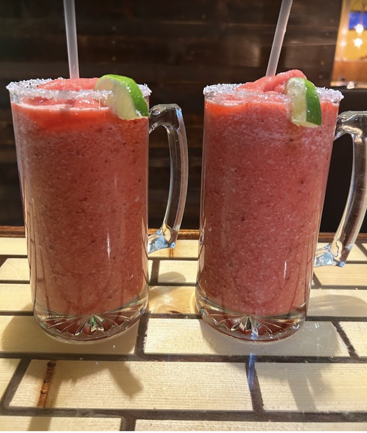 Two frozen strawberry daiquiris with lime