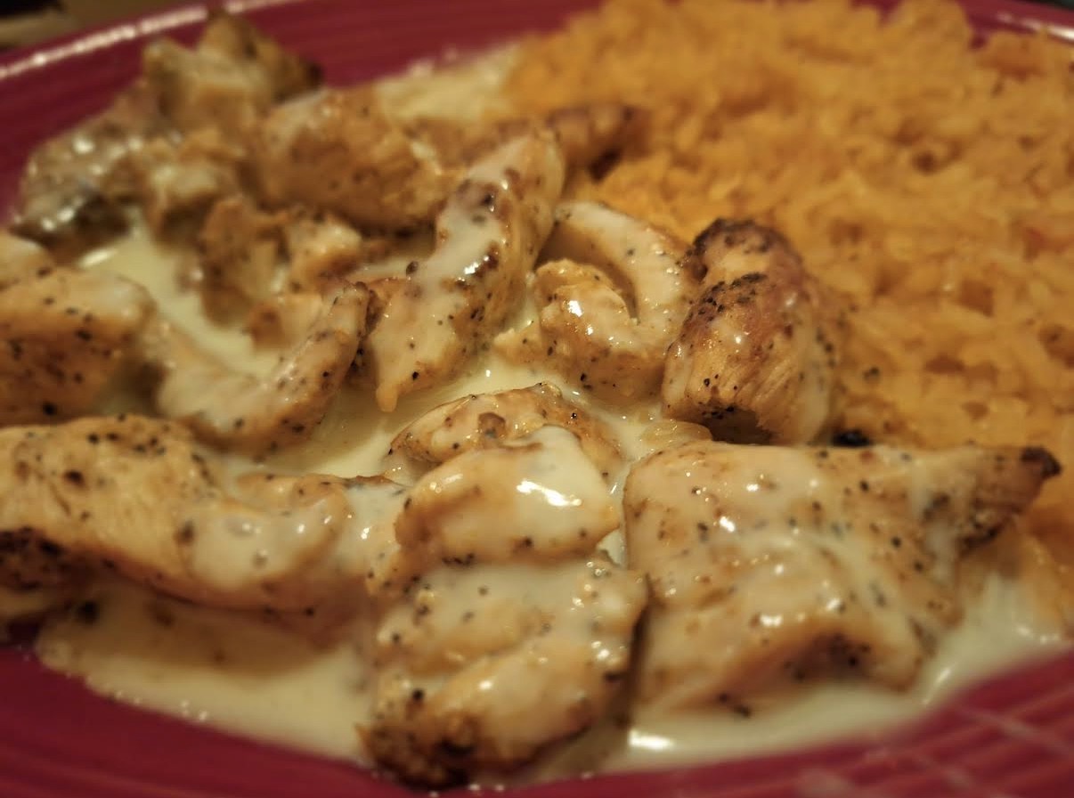 Mexican Chicken Fingers in creamy white cheese sauce with rice